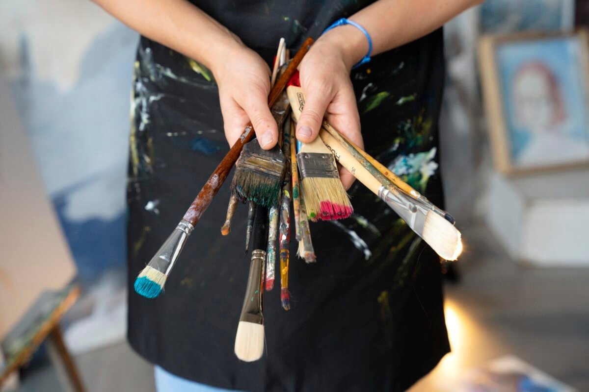 close-up-hands-holding-different-brushes